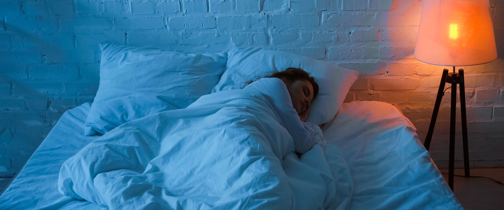 Entspannte Person schläft friedlich, umgeben von sanftem Licht, symbolisiert Wohlbefinden durch Nährstoffe.